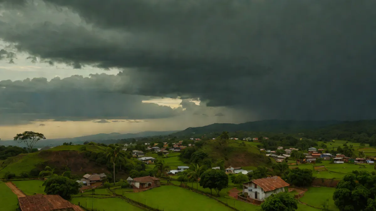 Vista de las afueras residenciales de Varginha bajo un cielo de tormenta al atardecer.