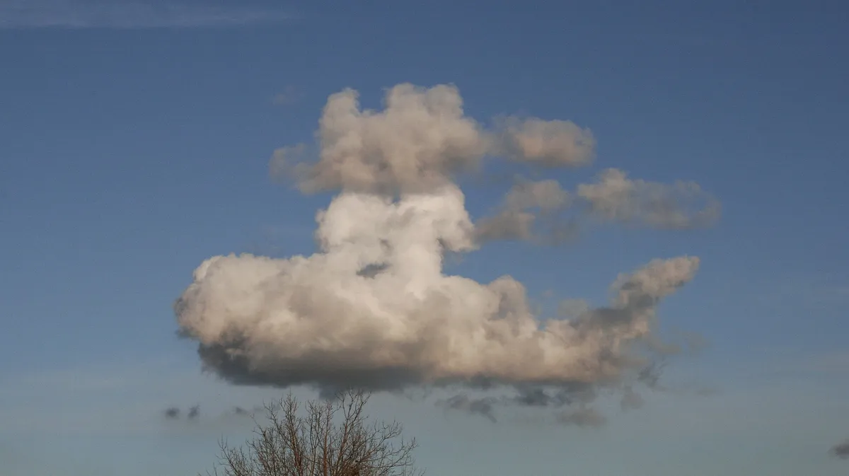Nubes blancas en un cielo azul que forman la silueta del perfil de un rostro humano.