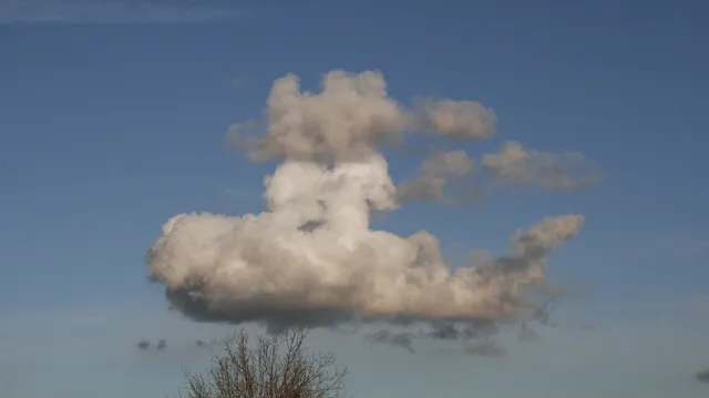 Nubes blancas en un cielo azul que forman la silueta del perfil de un rostro humano.